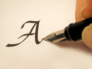 A quill pen writing the letter A